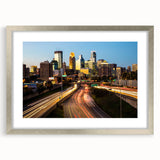 Textured art print depicting an abstract Minneapolis skyline in muted blue and gray tones on a silver-framed canvas.