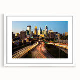 Abstract art print of Minneapolis skyline in muted gray and blue tones on a framed white mat, suitable for dining room decor.