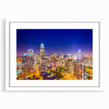 Abstract art print of Charlotte skyline in muted blue and gray tones on a white framed canvas.