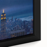 Close-up of black wall art featuring a textured depiction of NYC's Empire State Building in vibrant colors on a framed…