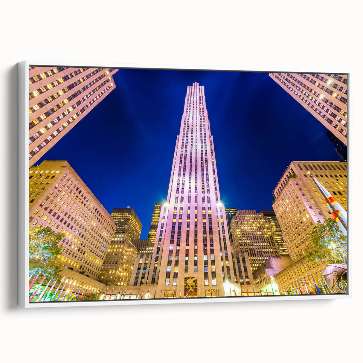 Vintage poster art of NYC Rockefeller view, framed canvas in white, featuring colorful skyline on black background.