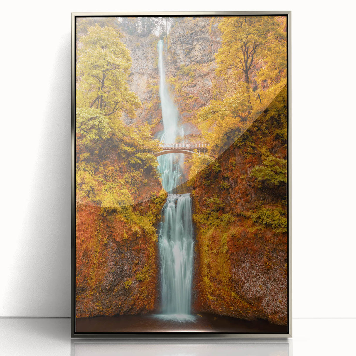 Mid-century modernist art of Multnomah Falls in Oregon, depicted in muted green and blue tones, framed in silver acrylic.