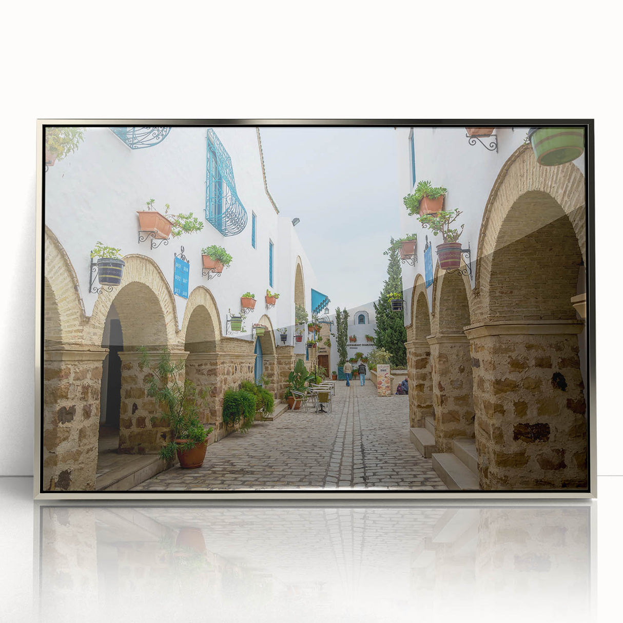 Mid-century modernist art of a Tunisian landscape on silver-framed acrylic, featuring earthy tones.