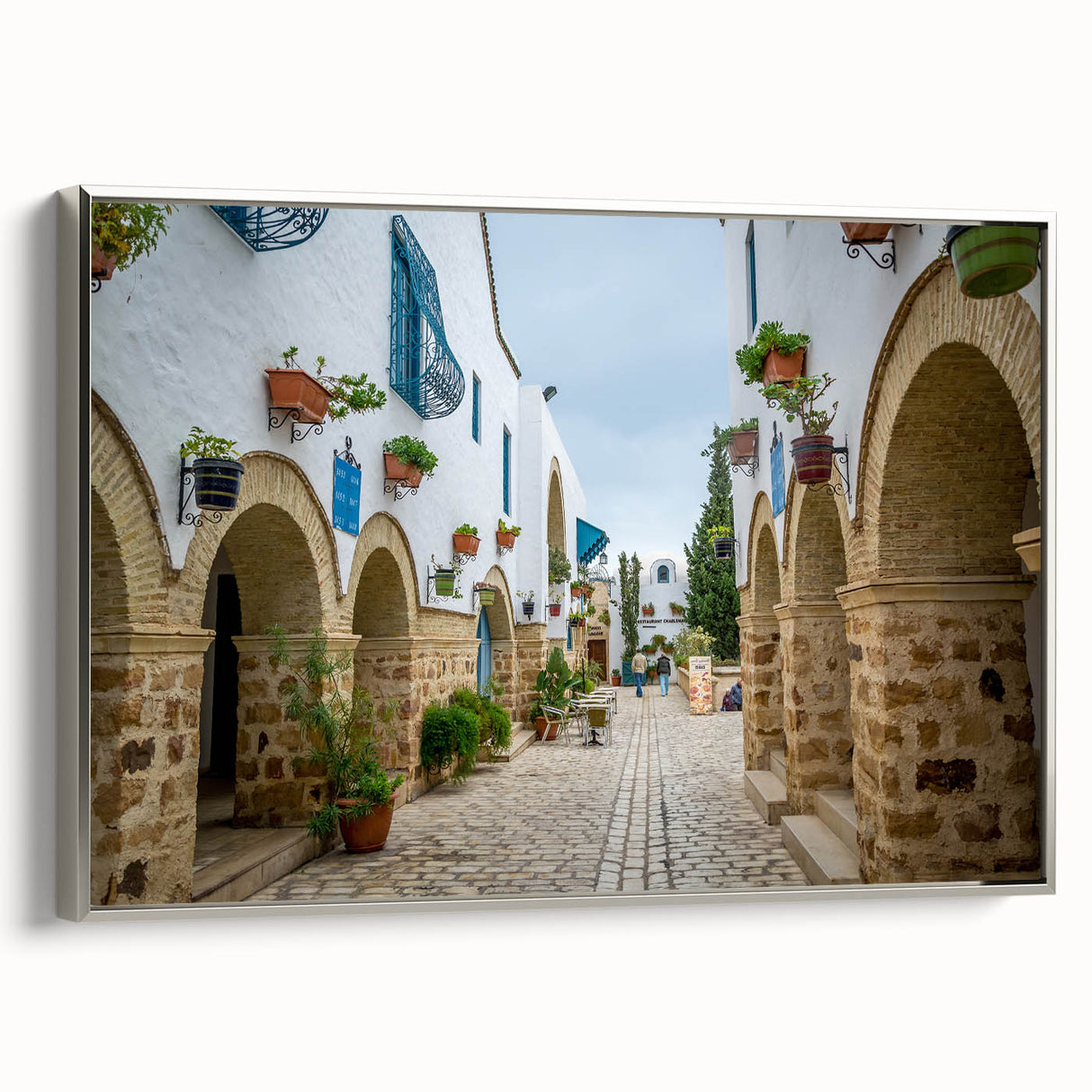 Landscape art painting of a Tunisian scenery on a silver-framed canvas, featuring vibrant.