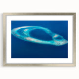 Textured art depicting an abstract Maldivian seascape in cool blue and white tones, framed in silver, ideal for bedroom art.