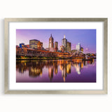 Abstract art print of Melbourne skyline in muted blue and gray tones on a framed silver mat, ideal for dining room decor.