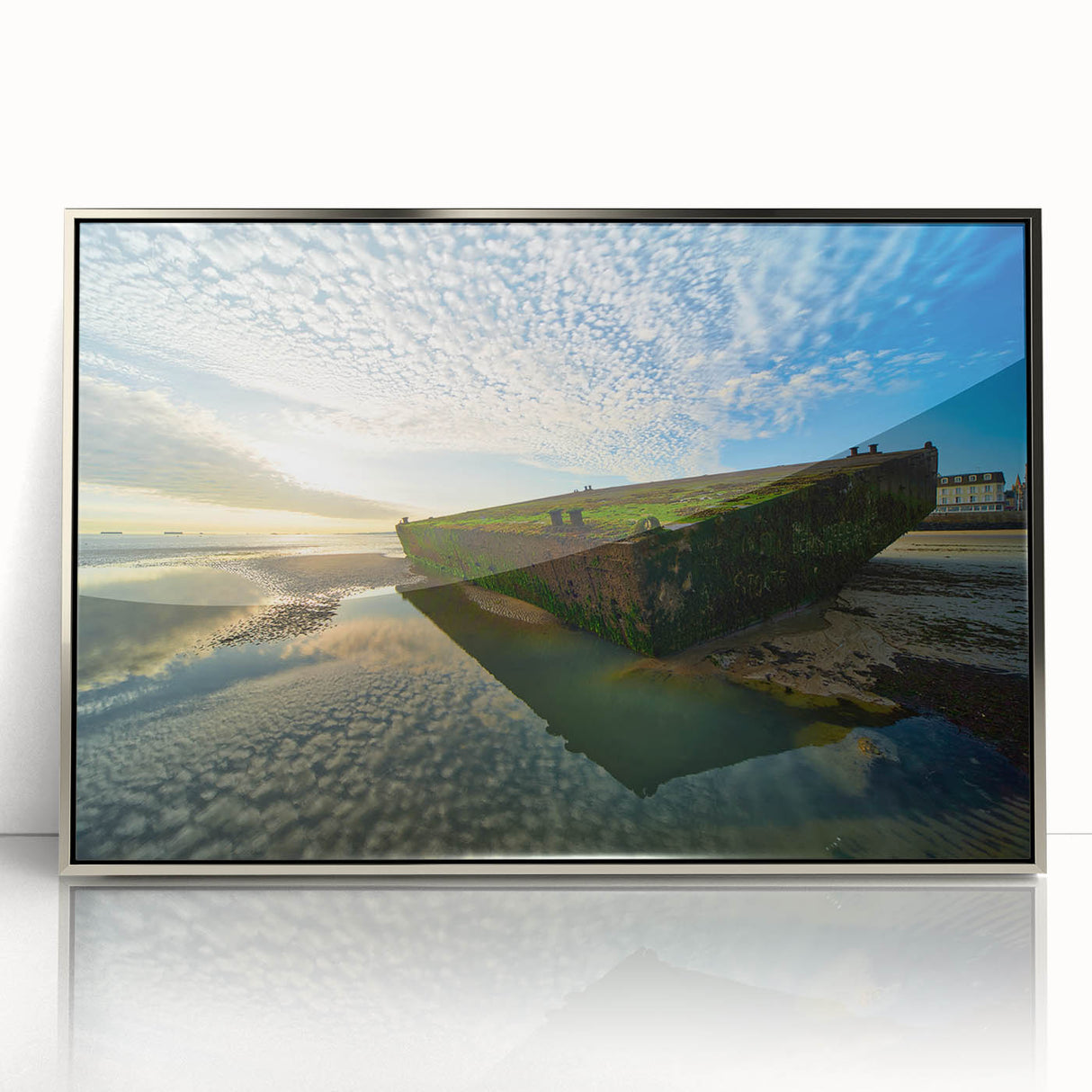 Large art print of Normandy scenery on a silver-framed acrylic, showcasing muted earth tones.