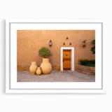 Abstract art print of a Saudi Arabian landscape in muted earth tones on a white framed canvas.