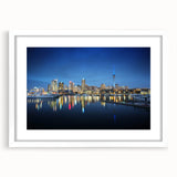 Abstract art print of Auckland's skyline in muted blue and gray tones on a white framed canvas.