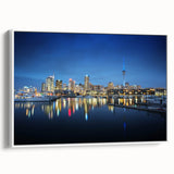 Vintage poster art of Auckland skyline in vibrant colors on a white-framed canvas.