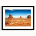 Colorful abstract art print of Monument Valley in vibrant hues on a large framed canvas, ideal for living room decor.