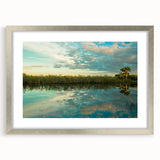 Textured art print of abstract Everglades scenery in muted green and blue hues on a framed silver mat.