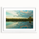 Abstract art print of Everglades scenery in muted green and blue tones on a white framed canvas.