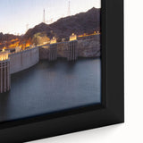 Close-up of a textured black wall art depicting Hoover Dam, with colorful accents, on a framed canvas.