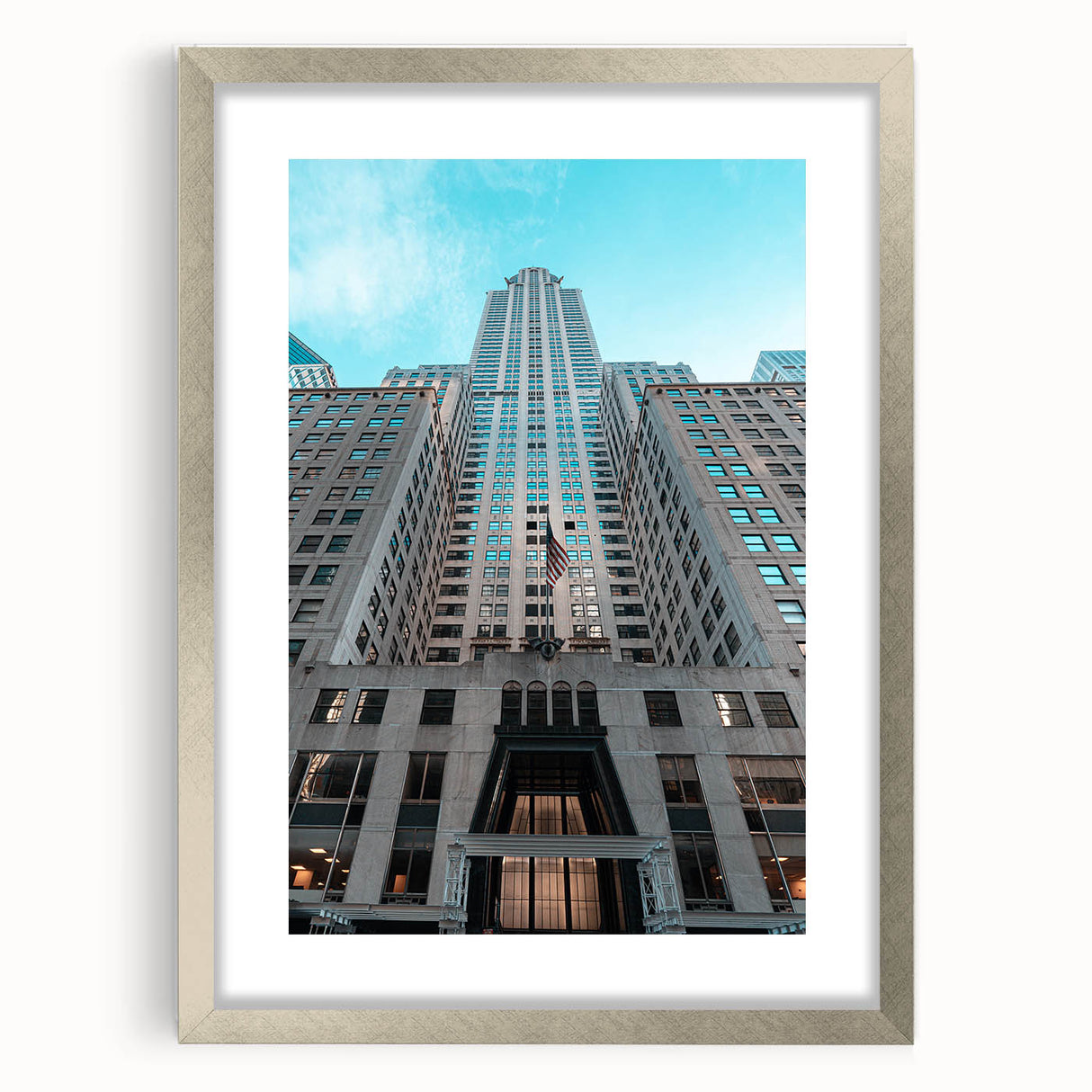 Textured art of the Chrysler Building in muted gray tones, framed with a silver mat, suitable for bedroom decor.