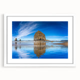 Abstract art print of Cannon Beach, Oregon, in muted gray and blue tones on a framed white mat.