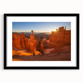 Colorful abstract art print of Bryce Canyon in vibrant orange and red tones, framed in black, ideal for living room decor.
