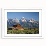 Abstract art print of the Grand Tetons in muted green and blue tones, framed with a white mat, ideal for dining room decor.