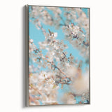 Framed canvas featuring a vintage-style landscape painting of spring with vibrant green and floral hues.