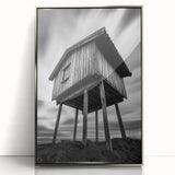 Mid-century modernist art depicting geometric shapes in neutral tones on a silver-framed acrylic print.
