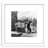 Abstract art print of people dining, using muted earth tones on a white framed mat, ideal for dining room decor.