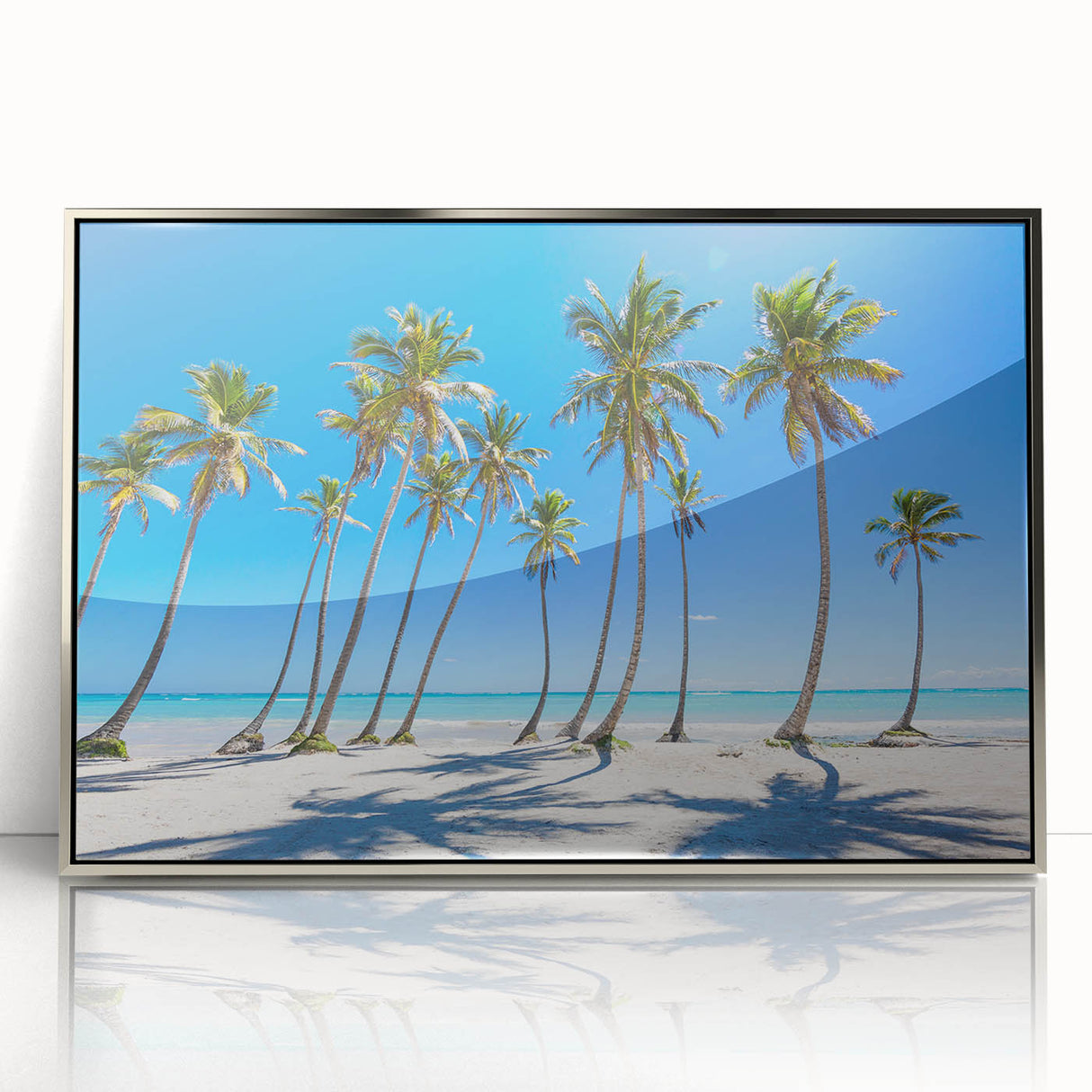 Art deco poster depicting a Caribbean beach scene, framed in silver acrylic, with soft blue and sandy hues.