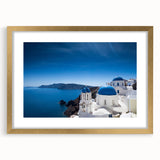 Abstract art print of Santorini with blue and white tones on a framed gold mat, suitable for dining room decor.