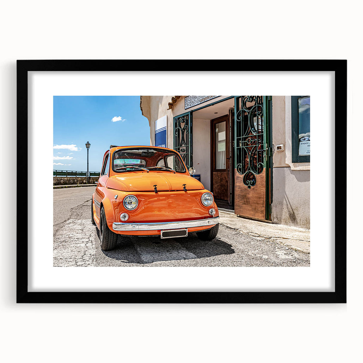 Colorful abstract art print of the Amalfi Coast in vibrant hues, framed in black, ideal for living room decor.