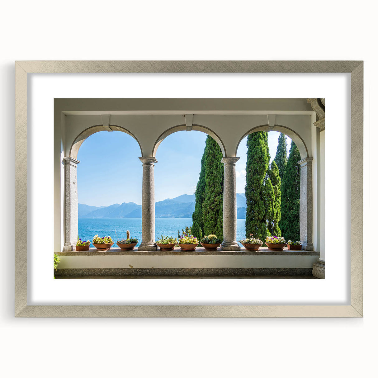 Extra large abstract art print of Lake Como with muted blue and green hues on a textured canvas, framed in silver.