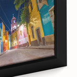Framed canvas featuring a textured depiction of Guanajuato, Mexico, with colorful houses and black accents.