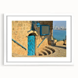 Abstract art print of Tel Aviv skyline in muted gray and blue tones on a framed white mat, suitable for dining room decor.