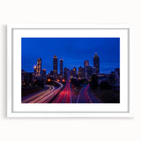 Abstract art print of Atlanta skyline in muted gray and blue tones, framed with a white mat, suitable for dining room decor.