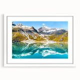 Abstract art print of Glacier National Park in muted blue and gray tones on a framed white mat, ideal for dining room decor.