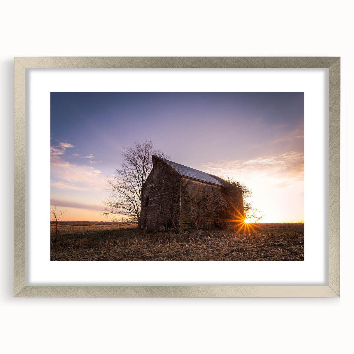 Textured art depicting abstract Nebraska scenery in muted earth tones, framed in silver, ideal for bedroom wall decor.