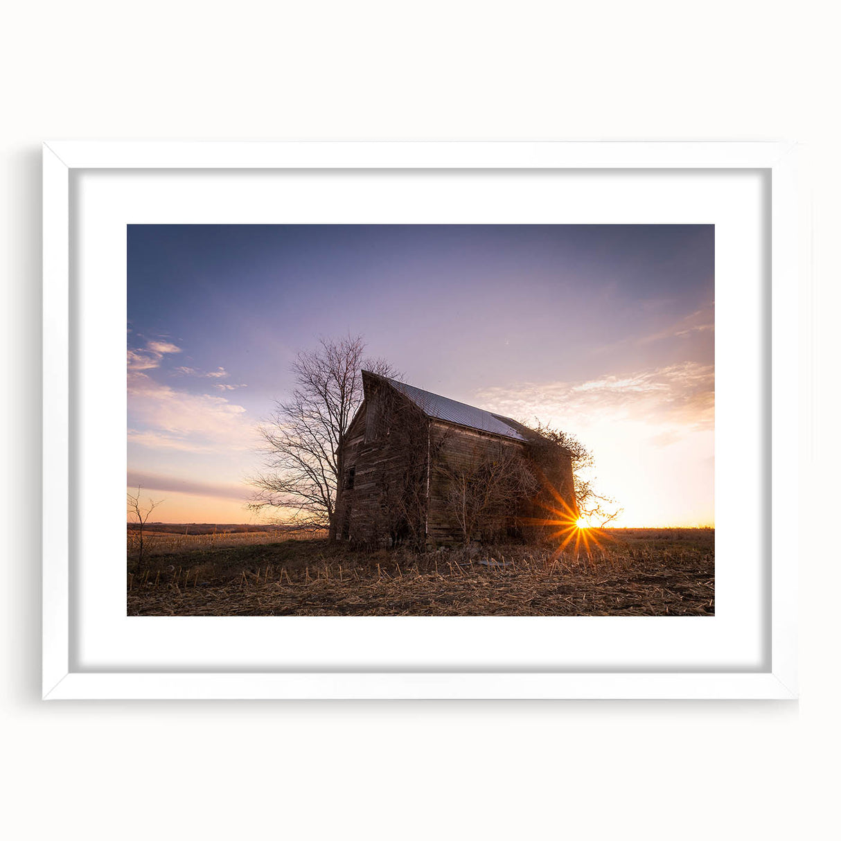 Abstract art print of Nebraska scenery in muted earth tones on a framed white mat, suitable for dining room decor.