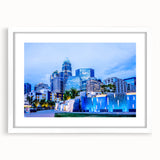 Abstract art print of Charlotte skyline in muted blue and gray tones on a framed white canvas.