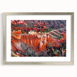 Textured art print of Bryce Canyon in muted orange and red tones, framed in silver, ideal for bedroom decor.