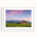 Abstract art print of the Grand Tetons in muted earth tones on a framed white mat, suitable for bedroom or dining room decor.