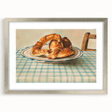 Textured art print of abstract pastries in muted brown and cream tones, framed in silver.