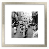 Textured abstract art print with silver frame, featuring indistinct figures and muted earth tones.