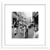 Abstract art print of stylized food and people in muted earth tones on a white framed mat, suitable for dining room decor.