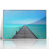 Acrylic print of a serene Maldives beach scene in soft blue and white tones, framed in white.