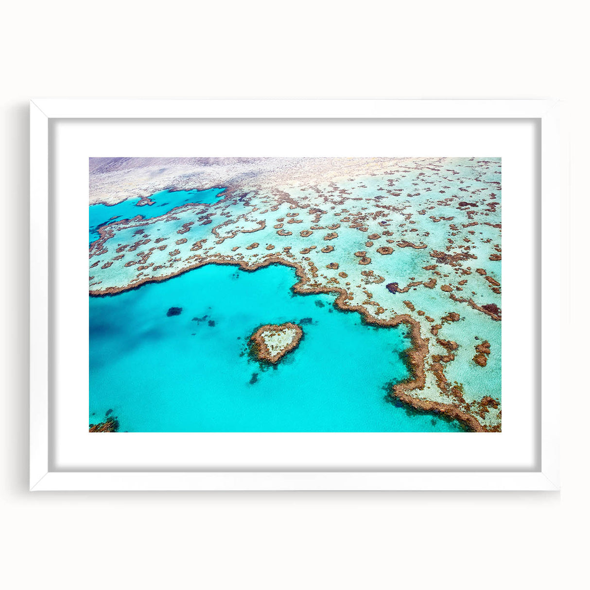 Extra large wall art of the Great Barrier Reef in vibrant blue and green tones, framed in white, ideal for living room decor.
