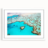 Extra large wall art of the Great Barrier Reef in vibrant blue and green tones, framed in white, ideal for living room decor.