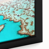 Black framed canvas of the Great Barrier Reef in vibrant blue and green tones, ideal for living room decor.