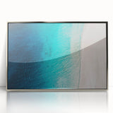 Large art print of a Caribbean scene in muted blue and green tones on a silver-framed acrylic.