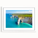 Textured abstract art print depicting a serene Normandy landscape in soft blue and green tones, framed with a white mat.