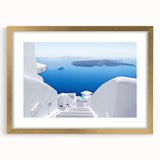 Abstract art print of Santorini with blue and white hues on a framed gold mat, suitable for bedroom or dining room decor.