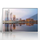 Acrylic print of Abu Dhabi skyline in subdued gray and white tones, framed in white, suitable for modern art wall decor.