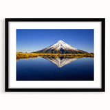 Abstract art print of Mt. Taranaki in vibrant, textured colors on a large black-framed canvas, ideal for living room decor.